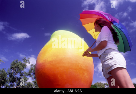 Mädchen mit Regenbogen farbige Schirm nach oben auf eine der großen Mango-Bowen-Queensland-Australien Stockfoto