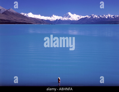 Einsame Gestalt stehen im Wasser mit Blick auf Lake Pukaki in Richtung Mount Cook Distanz Südinsel Neuseeland Stockfoto