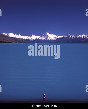 Einsame Gestalt stehen im Wasser mit Blick auf Lake Pukaki in Richtung Mount Cook Distanz Südinsel Neuseeland Stockfoto