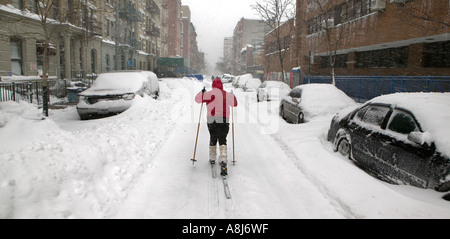 Eine junge Frau Langlaufski auf einer schneebedeckten Straße in Harlem nach einem Schneesturm in New York City USA Februar 2006 Stockfoto
