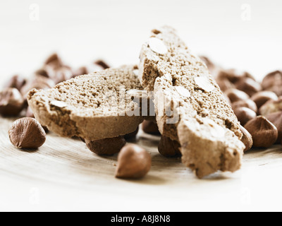 Haselnuss Biscotti Biskuit in Haufen auf ganze geschälte Haselnüsse Nahaufnahme gebleicht Stockfoto