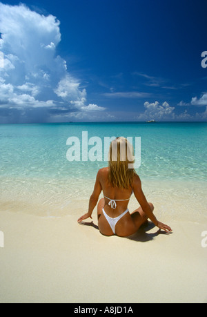 Cayman-Inseln Grand Cayman Frau im Tanga am Strand an der Wasserlinie Stockfoto