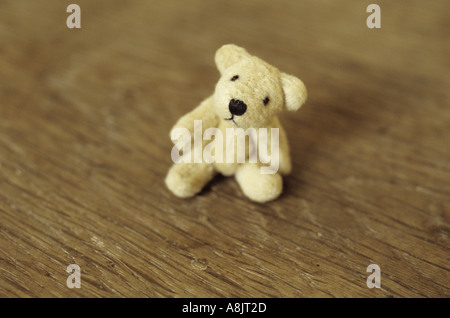 Kleinen Teddybär sitzend auf einem Holzsitz oder Tisch Stockfoto