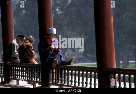 Lady zum Entspannen in der Sonne am Nachmittag entlang der "langen Korridor" am Eingang zu den Himmelstempel in Peking Stockfoto