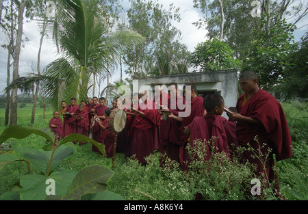 Tibetische Mönche singen und Instrumente spielen, während ein Gebet und Feuer Puja für den Weltfrieden im Kloster Drepung zusammenziehen in Indien. Stockfoto