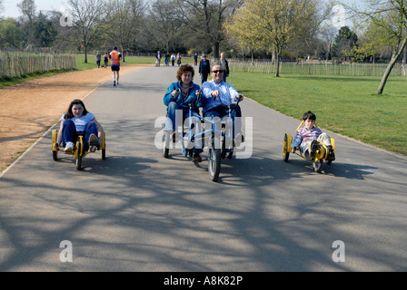 Familie in Dulwich Park auf verschiedene Arten von recumbent Fahrräder und Karren. Stockfoto