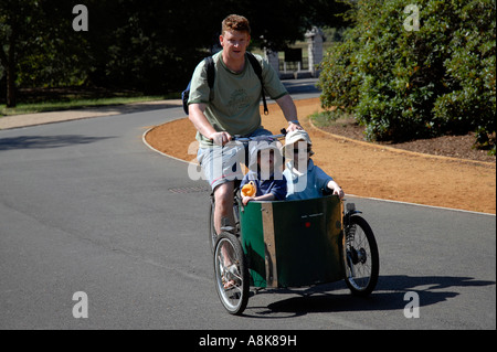 Vater mit zwei Kindern im Warenkorb auf T Fahrrad Zyklus in Dulwich Park in London. Stockfoto