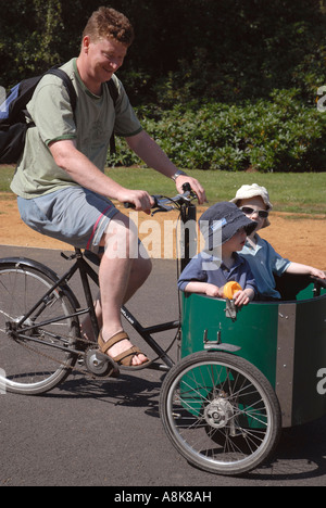 Vater mit zwei Kindern im Warenkorb auf T Fahrrad Zyklus in Dulwich Park in London. Stockfoto