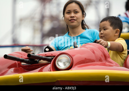 Mutter und Sohn genießen die Astro Fighter ritten Genting Highlands Outdoor Freizeitpark, Malaysia Stockfoto