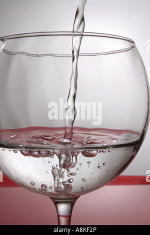 Wasser in ein Glas gegossen wird Stockfoto