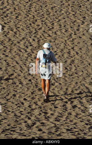 Ein Senior-Mann geht auf Sanddünen am Strand Playa Ingles in Maspalomas auf Gran Canaria, einer der Kanarischen Inseln Spaniens, spazieren Stockfoto