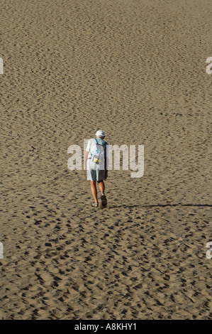 Ein Senior-Mann geht auf Sanddünen am Strand Playa Ingles in Maspalomas auf Gran Canaria, einer der Kanarischen Inseln Spaniens, spazieren Stockfoto