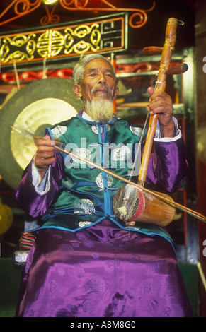 Ein Musiker der Naxi-Minderheit ein zwei saitige Geige zu spielen, bei einem Konzert Lijiang Yunnan Provinz China Stockfoto