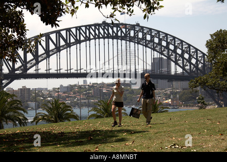 Paare, die auf Rasen mit Harbour Bridge hinter in Sydney New South Wales NSW Australia Stockfoto