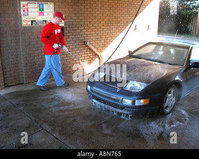 Menschen in sich selbst dienen Autowäsche Reinigung seiner SUV Stockfoto