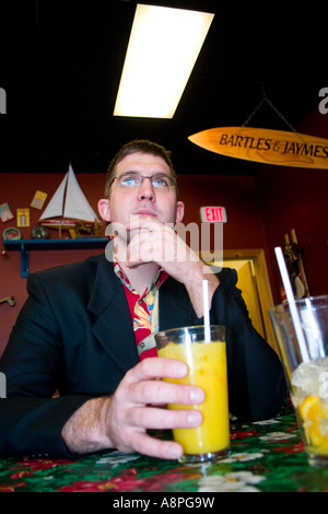 Mann sitzt im Restaurant mit seiner Orangensaft trinken. Bessemer Michigan USA großes Powderhorn Skigebiet Stockfoto