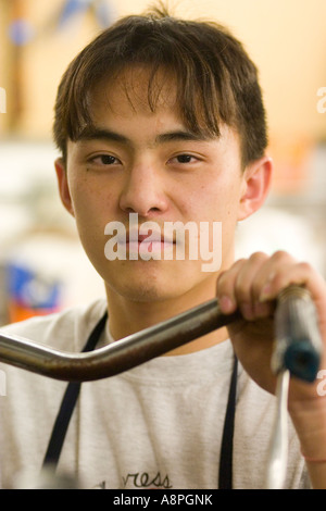 Porträt des asiatisch-amerikanische Mechaniker hält Fahrradlenker. Jugend Express Fahrrad Shop St. Paul Minnesota USA Stockfoto