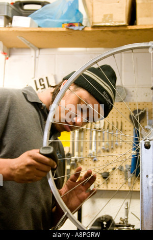 Arbeiter ein Fahrrad-Rad zu reparieren. Jugend Express Fahrrad Shop St. Paul Minnesota USA Stockfoto