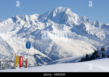 blau laufen Piste Marker Zeichen in den französischen Alpen über la Plagne mit dem Mont Blanc in der Ferne Stockfoto