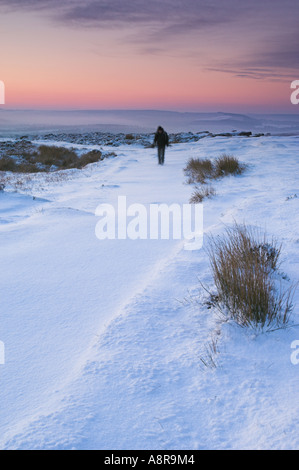 Wanderer im Schnee am frühen Morgen hochkant Froggatt Derbyshire Peak District National Park Calver England UK GB EU Europa Stockfoto