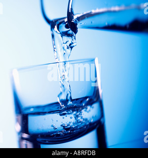 Wasser in Glas gießen Stockfoto