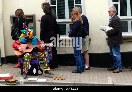 Straßenmusiker auf Bürgersteig vor der HSBC Bank Geldautomaten an der High Street in Hay on Wye Powys Wales UK Stockfoto