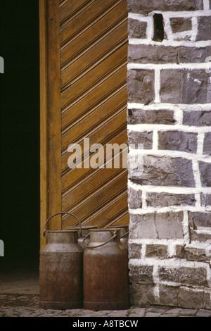 Milchkannen stehen vor einer Hütte Tür, Deutschland, Nordrhein-Westfalen, Sauerland Stockfoto