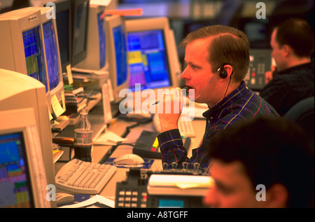 Händler sprechen auf Handys während des Sitzens vor der Computer in der Fannie MAE Marketroom in Washington D C Stockfoto