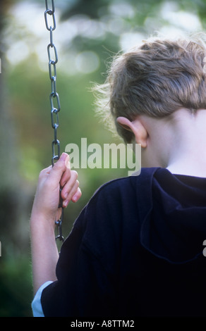 Junge auf Schaukel, denken Stockfoto