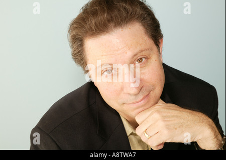 Studio Schuss eine Braunhaarige Mann mit seinem Kinn auf seine Hand und er hat einen düsteren Blick auf seinem Gesicht Stockfoto