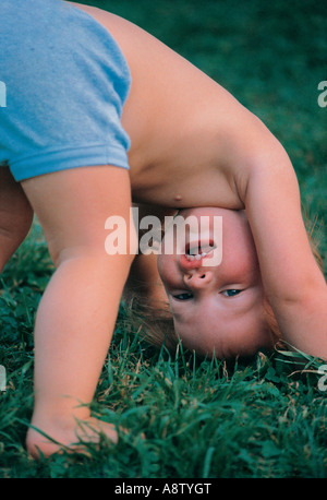 Kleinkind im Freien atempting einen Handstand. Stockfoto