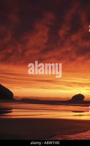 Lebendige Sonnenuntergang über Portreath Strand mit Gull Rock in der Silhouette, Nord-Westküste von Cornwall, England, UK Stockfoto