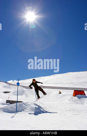 Verschneiten Skipisten des Prado Llano Skigebiet in der Sierra Nevada in Spanien mit Snowboarder machen einen Sprung Stockfoto