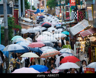 Regen fällt auf Regenschirme in belebten Takeshita-Straße in Harajuku Tokio Japan Stockfoto