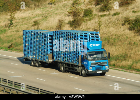 Seitenansicht von vorne für Volvo Tieflader LKW Abschleppen Anhänger beladen blaue Holzpaletten CHEP eine Tochtergesellschaft des Brambels Pooling-Geschäfts auf der britischen Autobahn Stockfoto