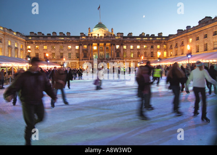 Erwachsene & Kinder Eisläufer mit Hintergrund historischen Somerset House Gebäude & Innenhof auf temporäre Winter Eislaufbahn Strand London, England, Großbritannien Stockfoto