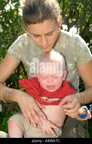 Eine Mutter Kleider ihre 8 - Monate alten Jungen. Stockfoto