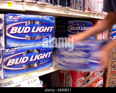 Bud Light Beer wird durch einen eifrigen Käufer aus einem Regal in einem Supermarkt entfernt. Stockfoto