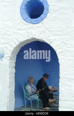 Altes Ehepaar entspannend im Tierheim am Wasser bei Portmeirion Dorf Wales Großbritannien UK Stockfoto