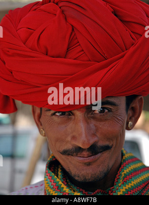 Junge indische lächelnd Mann aus Rajasthan mit Schnurrbart tragen rote Kopfbedeckungen Turban in Ujjain Kumbh fair India Stockfoto