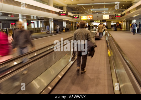 Passagiere die Esculator oder Rolltreppe verwenden, um ihren Weg durch Denver International Airport in Colorado zu beschleunigen Stockfoto