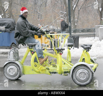 Ein Mann auf einem Fahrrad. Alternative Taxi. Fahrrad für sechs (oder sieben) und Fahrer.  Central Park. New York. USA. Winterschnee. Stockfoto