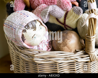 Sammlung von alten Puppen und Teddys in Korb Stockfoto