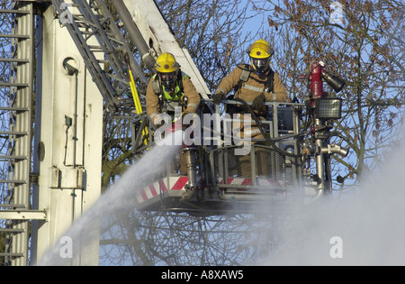 Hubarbeitsbühne wird von Feuerwehrleuten verwendet, um die Flammen ein Haus Feuer UK löschen Stockfoto