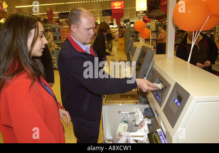 Shopper nutzt eine automatische Kasse in einem Sainsburys Store in Bury Park Luton UK Stockfoto