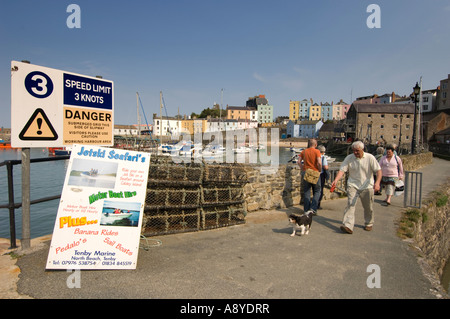 Tenby Wales - Menschen zu Fuß entlang der Hafenmauer Kai an einem Sommernachmittag Stockfoto