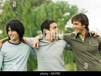 Drei junge männliche Freunde mit Arme um die Schultern Stockfoto