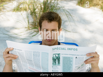 Menschen lesen Zeitung am Strand Stockfoto