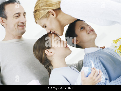 Familienszene, Mutter Tochter auf Kopf küssen Stockfoto