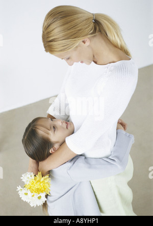 Familienszene, Mutter umarmt Tochter Stockfoto